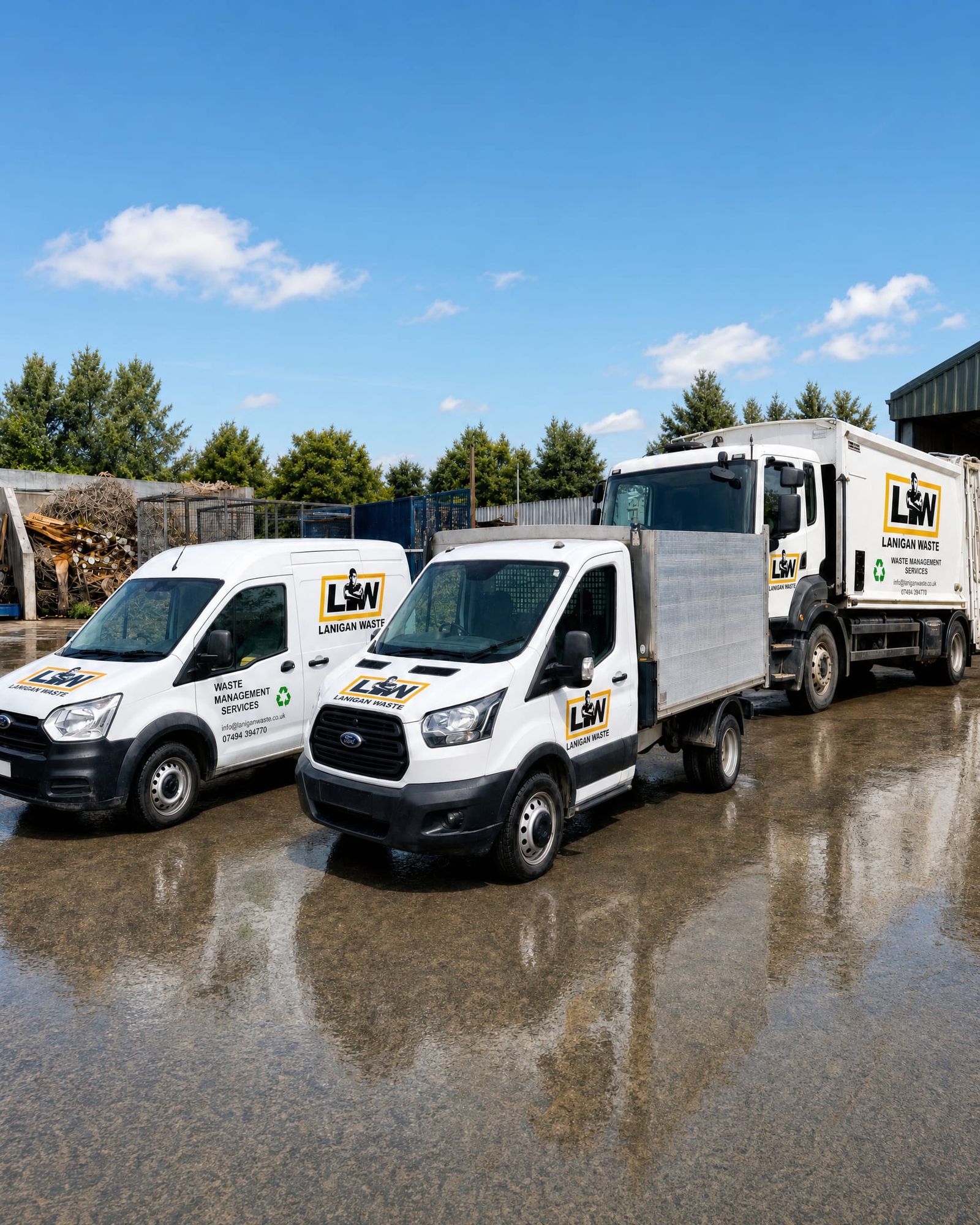 The Lanigan Waste fleet, sign-written vans, tipper and collection truck lined up in the yard on a sunny day